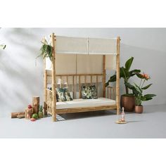 a wooden bed frame sitting next to a potted plant