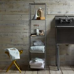 a towel rack in the corner of a bathroom next to a sink and a chair