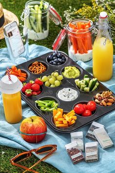 a muffin tin filled with lots of different types of fruit and veggies