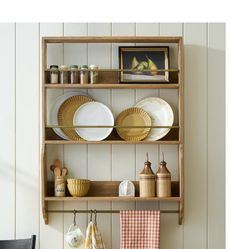 a wooden shelf with plates and bowls on it