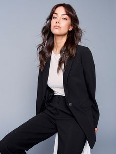 Step into modern elegance with our black blazer, featuring a chic ruched back for added flair. This sophisticated piece offers a timeless single-button closure, sleek front flap pockets, and a tailored fit that enhances your silhouette. Made from soft and stretchy fabric, it’s designed to seamlessly transition from work hours to evening outings while keeping you stylish and comfortable throughout the day. Adjustable ruched back detail Long sleeves with buttoned cuffs Lapel notch collar Single-bu Sleek Notch Lapel Blazer Dress For Business, Sleek Notch Lapel Blazer Dress For Business Casual, Chic Notch Lapel Blazer Dress With Pressed Crease, Chic Blazer Dress With Notch Lapel And Pressed Crease, Chic Business Suits With Hidden Button Closure, Chic Office Blazer Dress With Pressed Crease, Sleek Single Button Blazer Dress For Formal Occasions, Chic Tailored Blazer For Work, Sleek Notch Lapel Blazer Dress