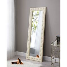 a large white mirror sitting on top of a floor