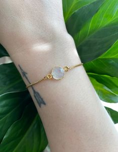 This minimalist style moonstone bracelet is perfect for everyday wear. It's beautiful on its own, but also makes a great layering piece. Created with a gold electroplated rainbow moonstone connector that is attached to a dainty gold plated chain with a slider bead that makes it adjustable. It is finished off with two gold ball ends. #gemstonejewelry #moonstone #minimalist Dainty Moonstone Bracelets For Everyday, Everyday Round Moonstone Bracelets, Dainty Round Moonstone Bracelets, Everyday Moonstone Bracelets, Adjustable Gold Moonstone Bracelet, Gold Moonstone Bracelet With Gemstones, Everyday Gemstone Bracelet With Moonstone, Gold Moonstone Round Bracelets, Spiritual Gold Bracelets With Moonstone