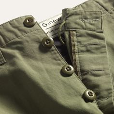 ALL-COTTON + RIPSTOP WEAVE + BUTTON FLY The Ginew Cargo Pant is inspired by Dad's Vietnam US ARMY field pants. The Cargo Pant is a relaxed fit, with a loose leg, and slightly oversized cargo pockets at the sides. He wore his field pants for decades as we would explore the woods, rivers, hills and marshes of the Great Lakes...he taught us to be outside and to hunt while wearing his US ARMY field pants. Many of our fondest memories as kids with him someway involved his field pants and occurred lon Pants Product Photography, Pants Flatlay, Field Pants, Shooting Ideas, Studio Photography Fashion, The Great Lakes, Pants Details, Green Cargo, Cargo Pant