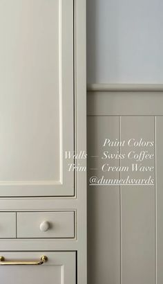 a white cabinet with brass handles and drawers