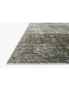 an area rug with grey and green colors on the floor, including a white background