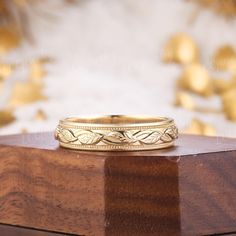 a gold wedding band sitting on top of a wooden box