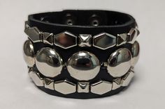 "This a handcrafted, full grain leather 1 - 3/4\" wide Cuff/bracelet.  The Leather is nice and soft, it will get buttery and more subtle with wear.   The leather is available in Midnight Black Onyx   The studs/spikes are a combination   The studs have a nice luster to them. These studs are plated in a nice nickel plating. The studs look like silver/Chrome This wristband/Bracelet is basically a one-size fits all. it will fit most wrists from up to an 8\" wrist" Studs And Spikes, Wristband Bracelet, Nickel Plating, Wide Cuff Bracelets, Wide Cuff, Silver Studs, Black Onyx, Cuff Bracelet, Rocker