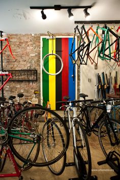 several bicycles are parked in a bike shop with colorful doors and shelves on the wall