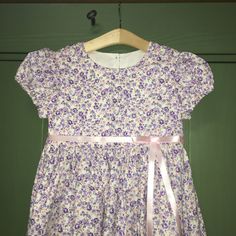 These beautiful brand new handmade mid calf length dresses is a girl's dream with an adorable purple calico set off with a satin pink ribbon and bow. Available in sizes 24 months- 14 years. Bonus! Comes wrapped in brown paper with colored twine! Ideal for Easter, gatherings, special occasions, picnics, parties, and everyday wear. Want a matching bonnet? https://www.etsy.com/listing/1064307888/whitepink-calico-children-pioneer Care:  Wash and dry on your machines' delicate settings with cold water and then put it in your dryer on low or delicate setting, take out as soon as your machine is done and hang it up on a hanger.  No ironing required! This dress was crafted in a smoke free environment. This item is made and created in the USA with pride Purple Short Sleeve Dress For Dress-up Events, Purple Short Sleeve Dress Up Dresses, Lavender Floral Print Cotton Dress, Lavender Cotton Dress For Garden Party, Lavender Cotton Dress With Floral Print, Purple Cotton A-line Dress, Lavender Cotton Dress With Short Sleeves, Toddler Picnic, Calico Dress