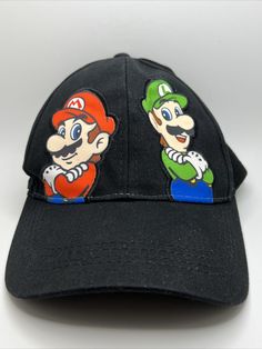 🔥🔥BRAND NEW WITH ORIGINAL TAGS NEVER WORN🔥🔥Show off your love for the iconic video game duo with this Super Mario Luigi Official Nintendo 2012 Black Strap Back Lid Cap. Made from 100% cotton and in a classic denim fabric type, this trucker hat is perfect for any season. The adjustable strap ensures a comfortable fit for any head size and the vintage design adds a touch of nostalgia. Featuring the colorful and classic characters of Mario and Luigi, this hat is a must-have for any gamer or fan Fun Black Cotton Baseball Cap, Retro Black Cotton Baseball Cap, Black Novelty Cotton Hat, Super Mario Luigi, Super Mario And Luigi, Classic Characters, Mario Luigi, Mario And Luigi, Denim Fabric