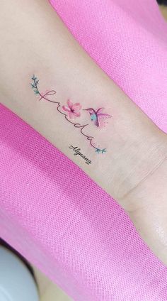 a woman's arm with pink flowers on it and the word love written in cursive writing