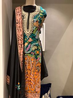 A stunningly marvellous outfit featuring Kashmiri Aari and Tilla fusion Embroidery. - - - - - - - - - - - - - - - - - - - - Product Details- Condition: Brand New (made to order)- Dress Style: Indian Salwar Suit- Embroidery: Kashmir Aari & Tilla Work- Base Color: Black- Embroidery Color: Multi-ColourF A B R I CShirt: Viscose GeorgetteDupatta: ChiffonLower: Indian CrepeF I N I S HUnstitched/Semi-StitchedYou can get it stitched locally.47+ inches of Shirt Length and up to full sleeves length.St Fitted Dress With Multicolor Embroidery For Diwali, Designer Multicolor Dress With Intricate Embroidery, Designer Multicolor Embroidered Dress For Diwali, Bollywood Style Designer Multicolor Embroidered Dress, Bollywood Style Multicolor Embroidered Designer Dresses, Raw Silk Dress With Multicolor Resham Embroidery, Festive Raw Silk Dress With Multicolor Embroidery, Designer Multicolor Embroidered Traditional Dress, Designer Multicolor Embroidery Dresses For Festivals