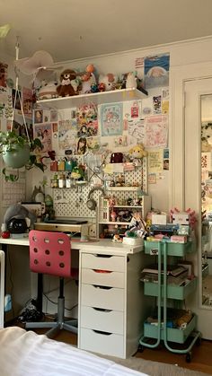 a bedroom with a desk and shelves filled with stuff on the wall, along with many other items