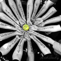 a group of people with their hands together in a circle holding a ball that says love