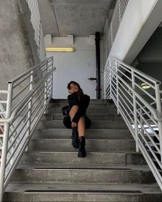 a woman sitting on some stairs with her legs crossed