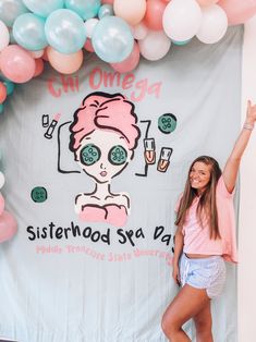 a woman standing in front of a sign with balloons around her and the words sisterhood sea day written on it