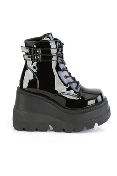 a pair of black and white platformed boots with metal accents on the soles