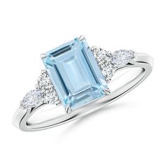 an aqua blue topazte and diamond ring with three diamonds on the sides, set in