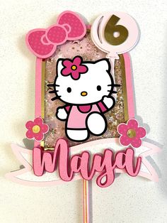 a hello kitty cake topper on a stick