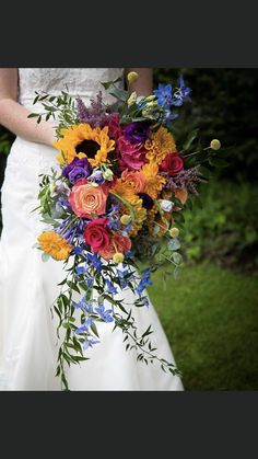 a bride holding a colorful bouquet of flowers