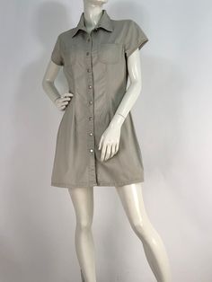 "Vintage khaki dress, button front dress, squeeze jeans size medium  Measurements:  shoulder 16\"/sleeve 5\"/bust 19\"/waist 15\"/hip 19.5\"/length 32\" mannequin measures 5ft 8\", bust 34\", waist 25\", hip 33\" Please note that vintage clothing sizes can vary greatly.  The Measurements provided  are approximate and are taken lying flat.  I suggest taking a similar garment from your wardrobe and measure it while lying flat.  This way you can compare measurements.  All of our pieces are genuine vintage. Don't forget to enlarge the photos and take a closer look at this genuine vintage item!! International destinations other than US may take 4-6 weeks or longer unless you choose to upgrade shipping for faster delivery. Please note buyer is responsible for any duties, taxes or customs clearan Collared Cotton Mini Dress With Pockets, Fitted Khaki Mini Dress For Fall, Stretch Dress With Pockets And Short Sleeves, Spring Button-up Mini Dress, Casual Fitted Knee-length Shirt Dress, Fitted Solid Color Mini Shirt Dress, Fitted Summer Shirt Dress With Pockets, Fitted Solid Mini Shirt Dress, Solid Fitted Mini Length Shirt Dress