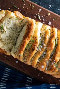 a loaf of garlic bread on a cutting board with salt and pepper sprinkles