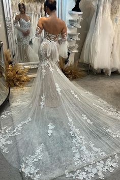 a woman is looking at her wedding dress in the mirror