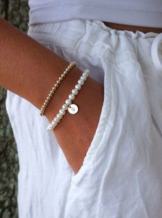 "Real Pearl Bracelet with Gold-Filled Initial: Created with Grade-A 6mm round freshwater pearls, a 14K gold-filled oval lobster clasp with a 1/2\" 14K gold-filled extender chain, and a 14K gold-filled disc with one initial. The initial can be placed front/center or near the clasp. The letter is unoxidized for soft/subtle look. The pearls are strung on super strong, stainless steel gold colored wire for extra durability. All metal components are 14K gold-filled.   The initial disc charm is 3/8\" Elegant Hypoallergenic Name Bracelet With Round Beads, Personalized Round Bead Pearl Bracelet In Elegant Style, Personalized Round Bead Pearl Bracelet, Elegant Personalized Round Bead Pearl Bracelet, Classic Personalized Pearl Bracelet, Personalized Classic Pearl Bracelet, Personalized Elegant Pearl Bracelet, Elegant Personalized Pearl Bracelet, Classic Personalized White Pearl Bracelet