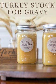 two jars filled with turkey stock for gravy sitting on top of a table