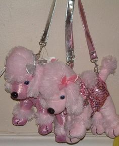 three pink teddy bears are hanging from a keychain on a hook in front of a wall