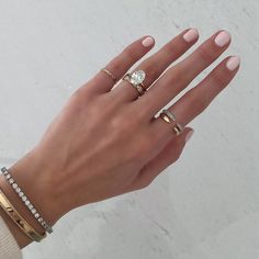 a woman's hand with three different rings on it