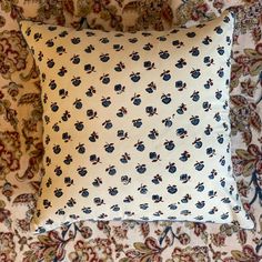 a white pillow with blue and red flowers on it