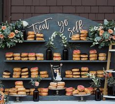 there is a display with donuts and flowers on the shelves that say treat yo self