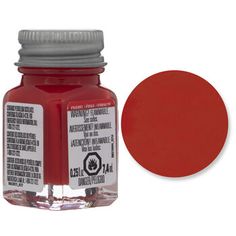 a bottle of red acrylic paint next to it's cap on a white background