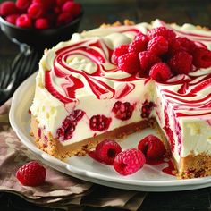 a cheesecake with raspberries is on a plate