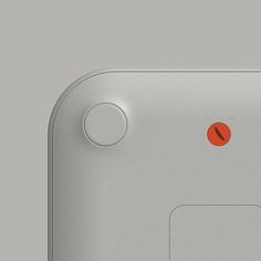 the back side of an electronic device with red buttons and two white circles on it