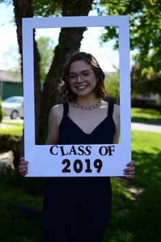 a woman holding up a sign that says class of 2019