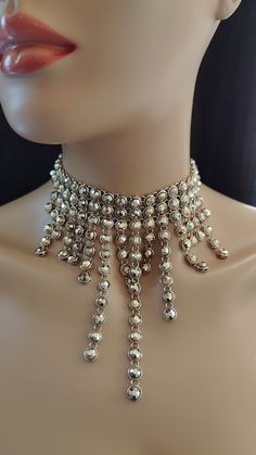 *This unique necklace is a statement piece that will make you stand out from the crowd. It is made of small circular metal pieces that are arranged in a cascading pattern.  *The metal pieces are gold in color and have a shiny finish.  *The necklace has a choker style with a long drop in the center.  *The necklace is adjustable in length and has a lobster clasp closure.  *This necklace is handmade with care and attention to detail. It will add a modern and edgy flair to your look. Metal Ball Chain Necklace For Party, Silver Chainmail Necklace For Party, Metal Chainmail Necklace For Party, Metal Round Choker For Party, Metal Choker For Party, Round Metal Choker For Party, Party Chainmail Metal Necklace, Party Metal Necklace With Ball Chain, Party Metal Ball Chain Necklace