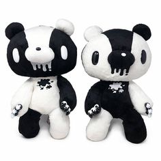 two black and white stuffed animals sitting next to each other