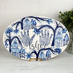 a blue and white platter with hand prints on the bottom that says, she