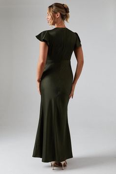 a woman in a green dress looking back