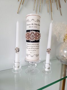 two candles are sitting on a glass shelf next to another candle and some other items