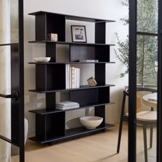 a black book shelf sitting on top of a hard wood floor