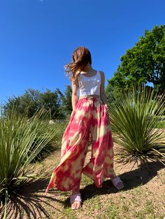 Step into a soft dreamscape of color with our Summer Tie-Dye Wide-Leg Pants. The perfect choice of vacation wear, these flared pants reflect free-spirited chic, letting you float through summer in unconfined comfort. Handcrafted from 100% Rayon, they offer exceptional breathability and a fluidic drape that keeps you cool and light as air all summer. It features an elasticated drawstring waist that offers an adjustable fit and side pockets for a practical flair. The vibrant tie-dye patterns captu Tie Dye Flare Pants Outfit, Bohemian Style Bottoms For Beach Season, Bohemian Bottoms For Beach Season Summer Outings, Summer Festival Wide-leg Harem Pants, Hippie Style Harem Pants For Beach In Spring, Summer Vacation Wide-leg Harem Pants, Spring Summer Beach Harem Pants, Hippie Harem Pants For Vacation In Spring, Wide Leg Harem Pants For Spring Vacation