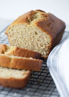 a loaf of bread sitting on top of a cooling rack next to a white towel