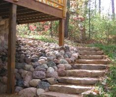 stone steps lead up to a deck in the woods