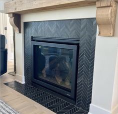 a fireplace with a black and white tile surround