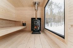 a wood burning stove in the corner of a room with wooden walls and flooring