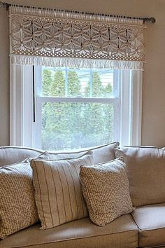 a couch sitting under a window next to pillows